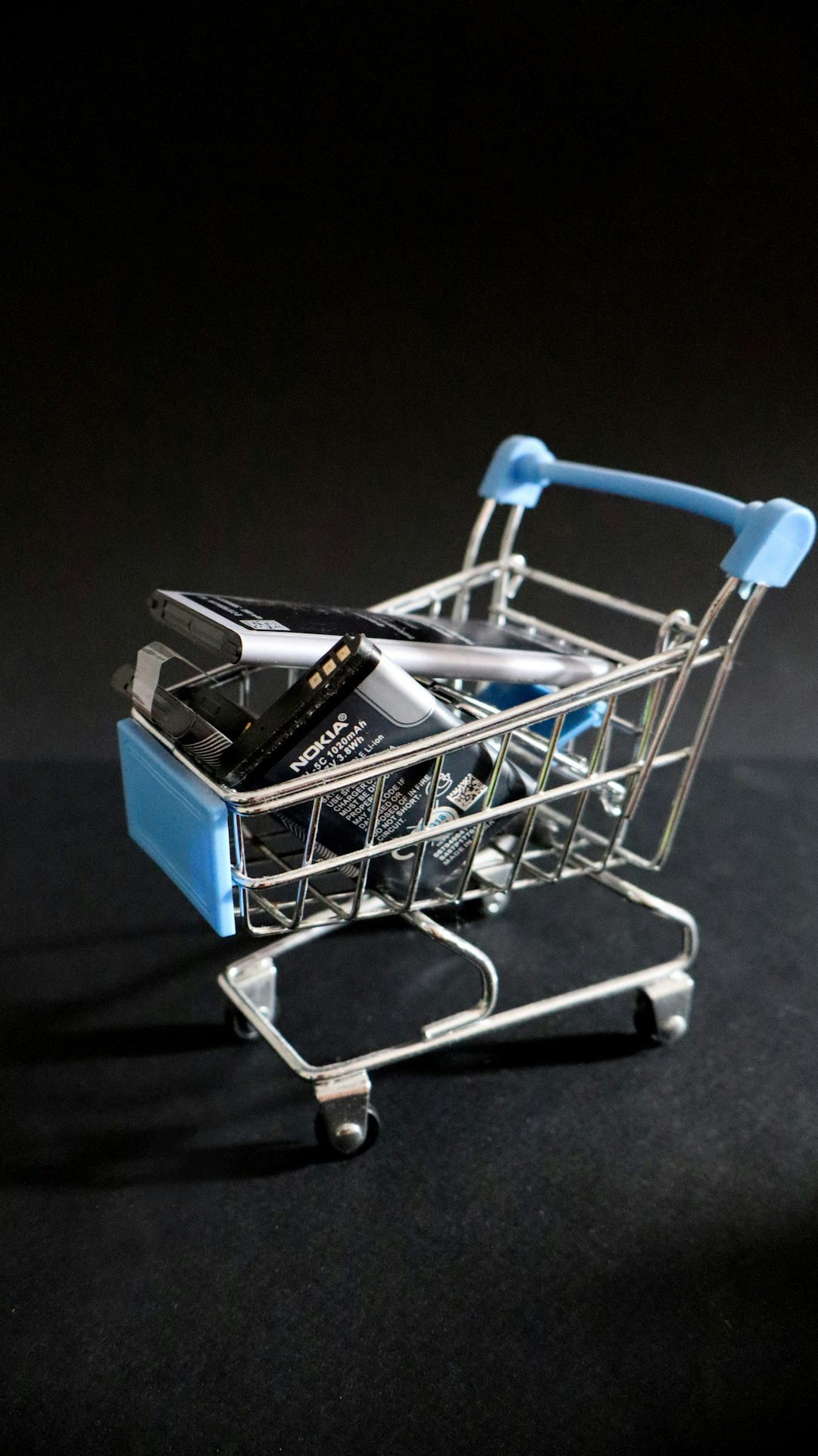 A miniature shopping cart with a cell phone in it