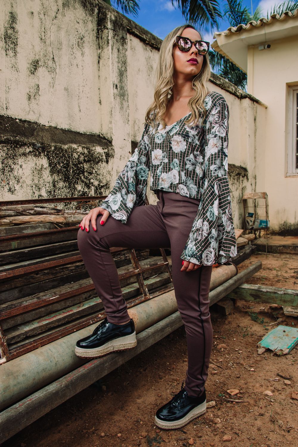 Trendy woman poses outdoors in a chic outfit and sunglasses, exuding confidence and style.