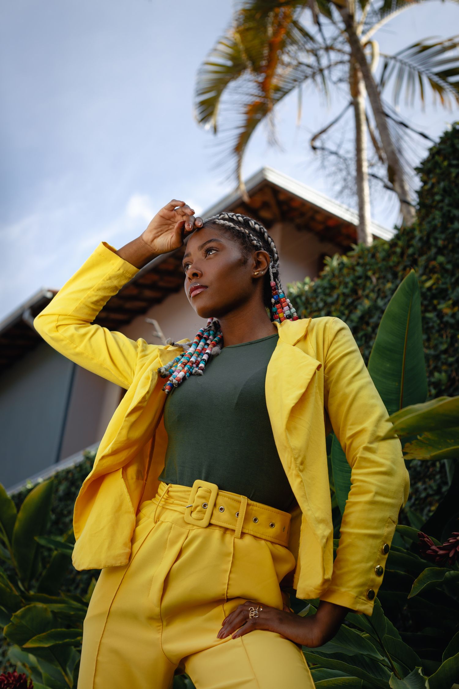 Stylish woman in vibrant yellow suit posing outdoors in Belo Horizonte, Brazil.