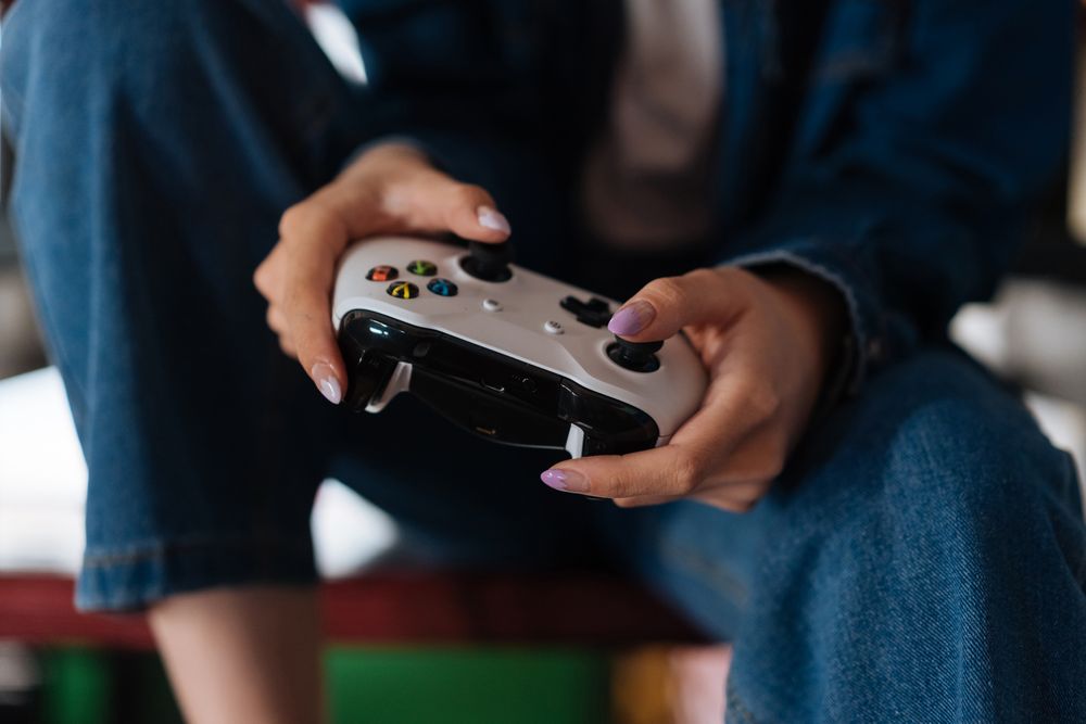 Hands holding a game controller during intense gameplay session.