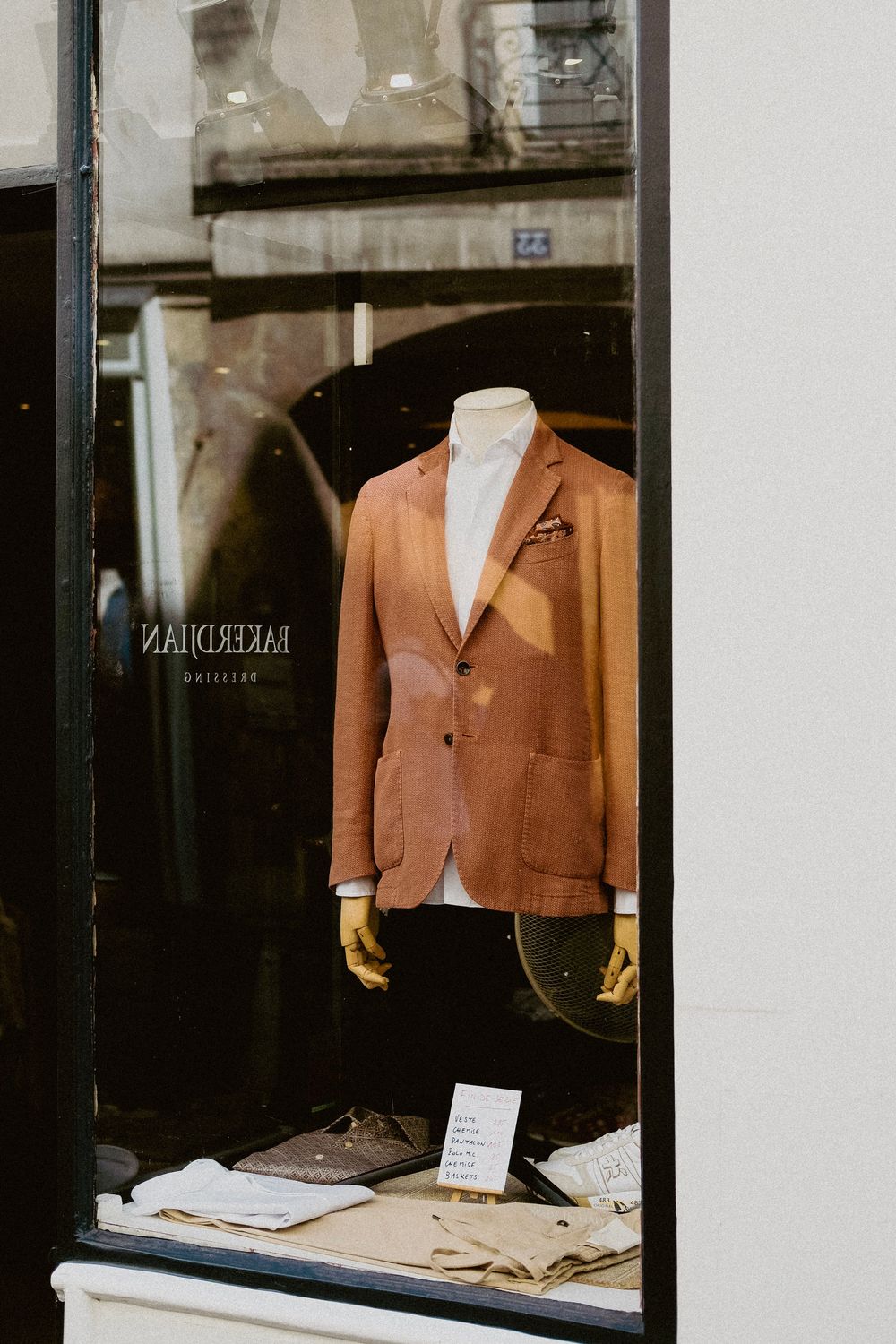 Sophisticated men's suit showcased on a mannequin in a boutique window display.