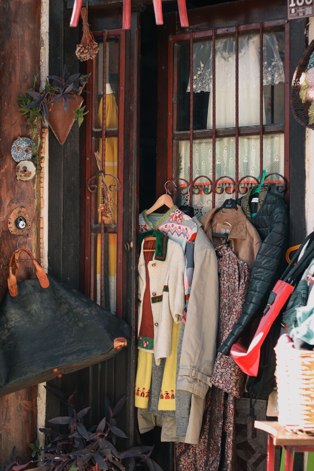 Charming display of vintage clothes at a rustic store entrance, capturing a nostalgic vibe.