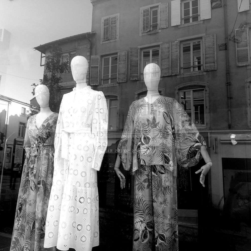 Stylish mannequin display showcasing modern fashion in a shop window in Nancy, France.