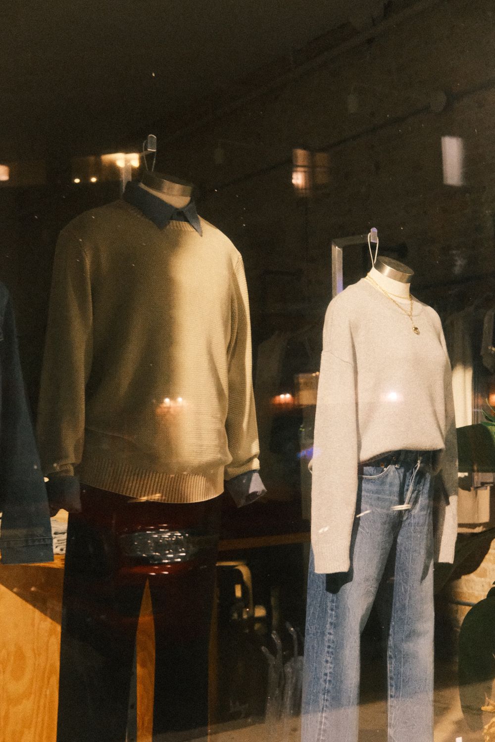 Fashionable window display featuring cozy sweaters and jeans.