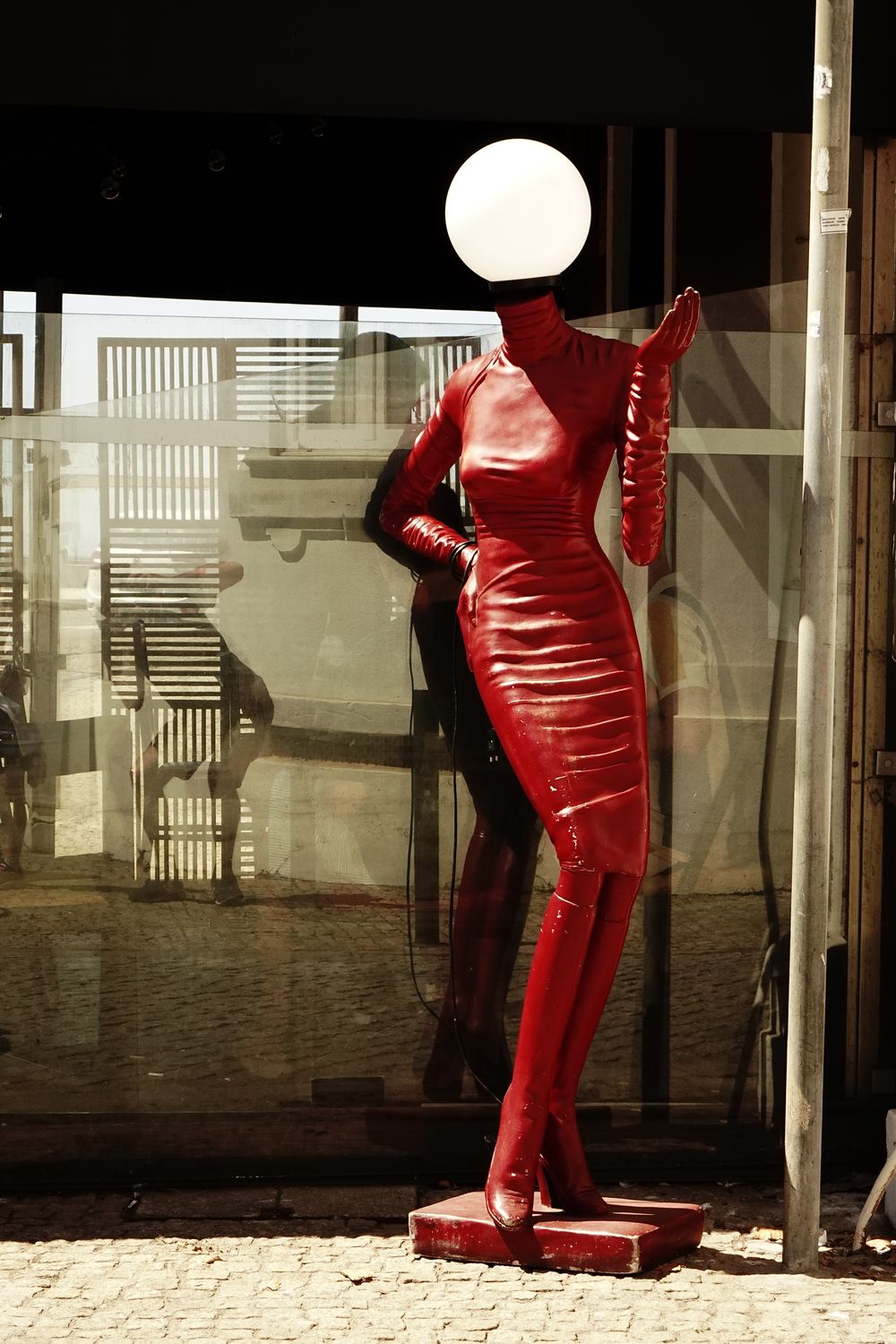 Bold red mannequin sculpture with modern design in outdoor setting. Perfect for fashion and art themes.