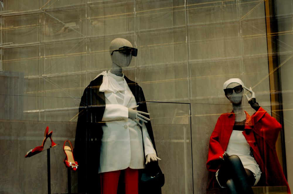 Elegant mannequins showcase stylish outfits in a Lviv storefront, exuding modern fashion vibes.