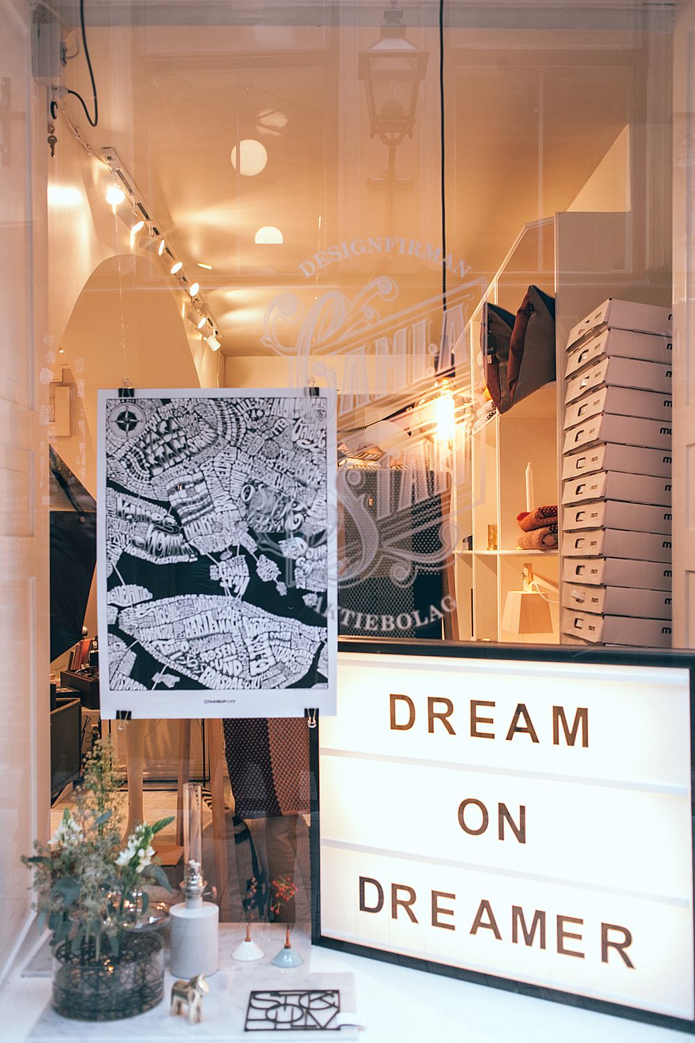 Exterior window of shop decorated with picture and signboard with inscription standing on windowsill