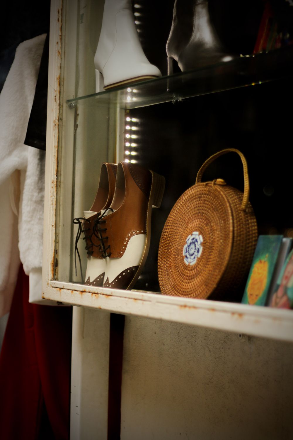 Stylish vintage shoes and a wicker handbag on display in a chic boutique.