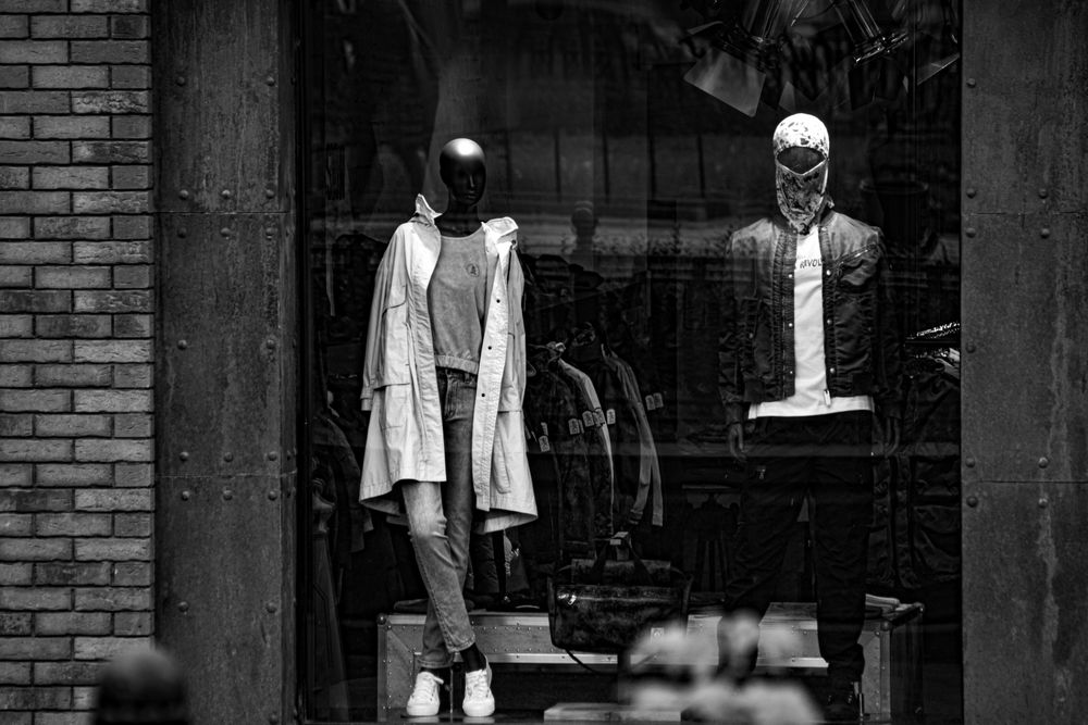 Shop window featuring stylish mannequins in trendy outfits for modern fashion appeal.